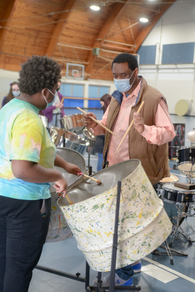 person receiving instruction on how to play the steel drum
