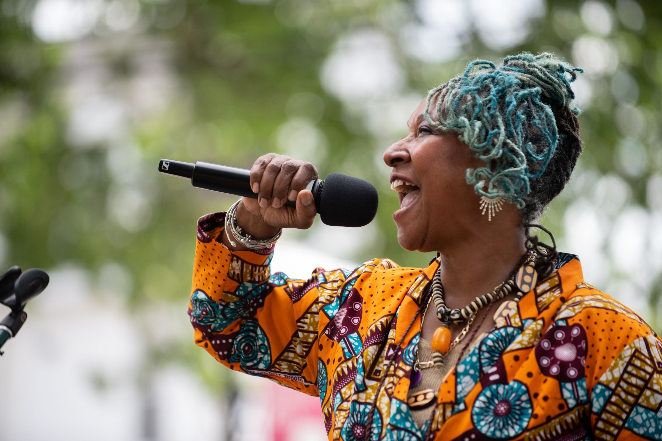 singing woman with green locs
